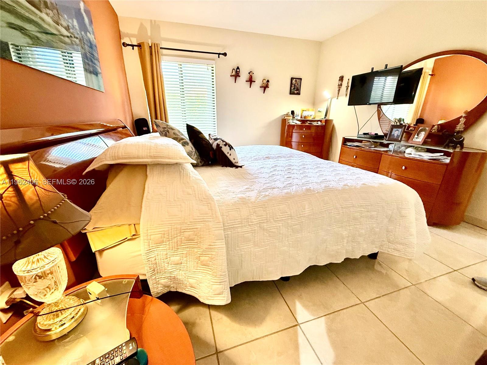 351 Club Circle, Unit 102 Boca Raton, FL 33487 - Photo 17 of 34 a bedroom with a bed and lamp