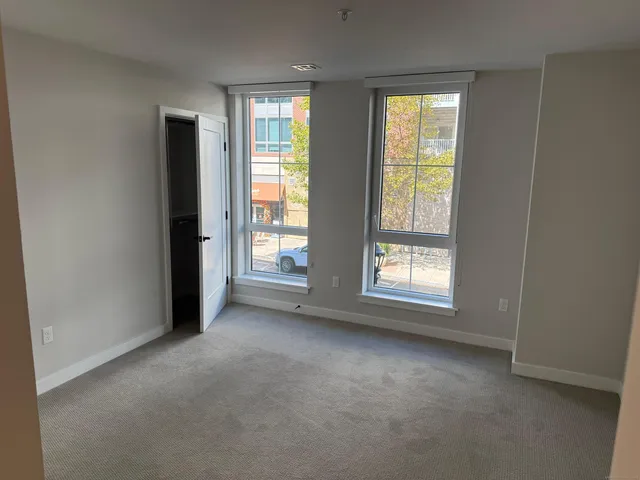 an empty room with windows and closet