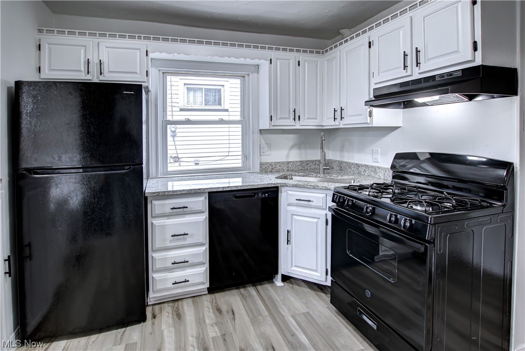 4764 Rockwood Road Cleveland, OH 44125 - Photo 7 of 35 Kitchen with black appliances, light wood-type flooring, sink, and white cabinetry