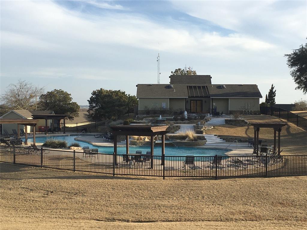 23077 Oak Ridge Drive Whitney, TX 76692 - Photo 8 of 12 a view of swimming pool with outdoor seating and buildings in the background