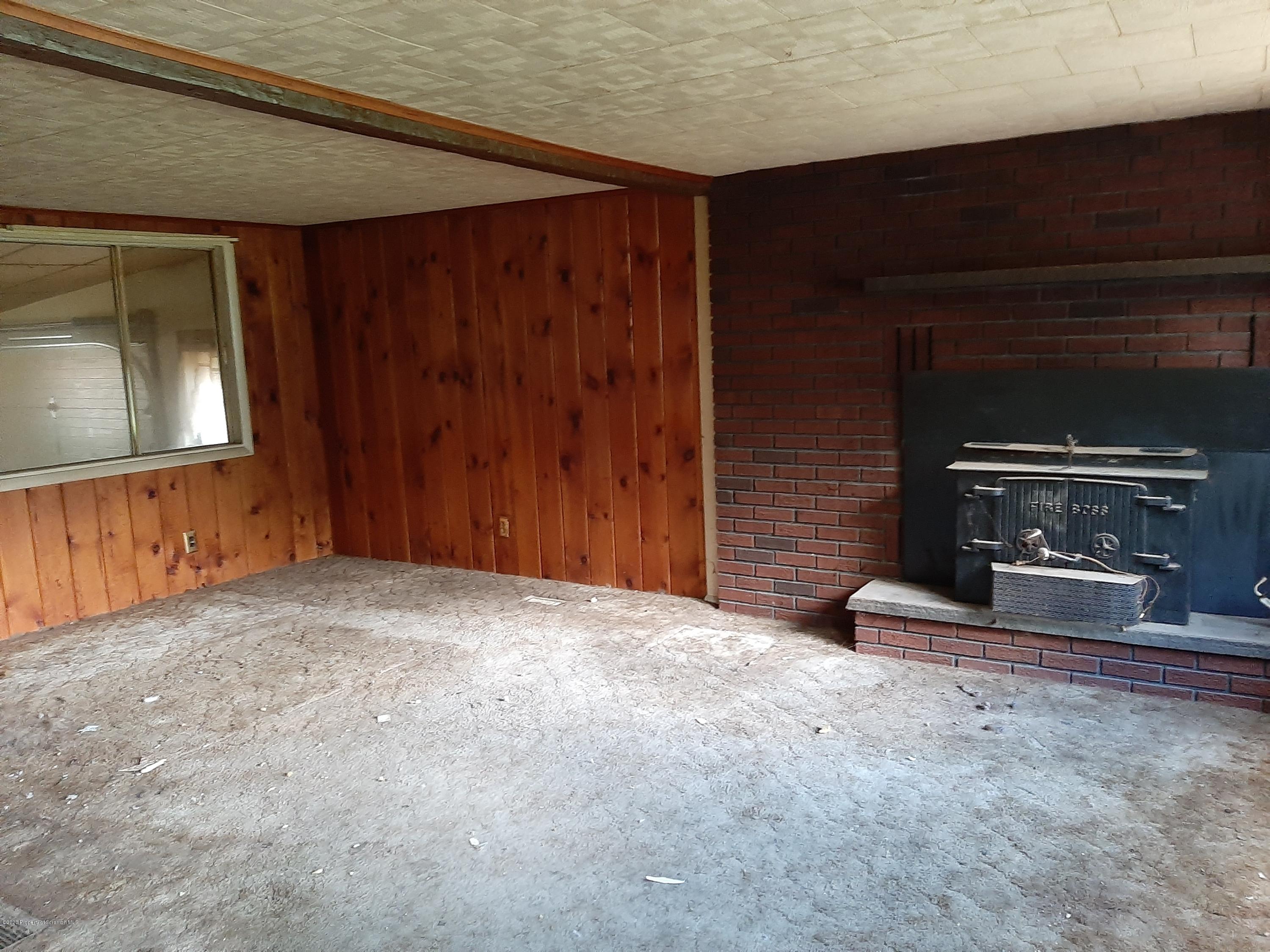 774 Creek Road Nicholson, PA 18446 - Photo 3 of 16 a view of an empty room with a fireplace and a window