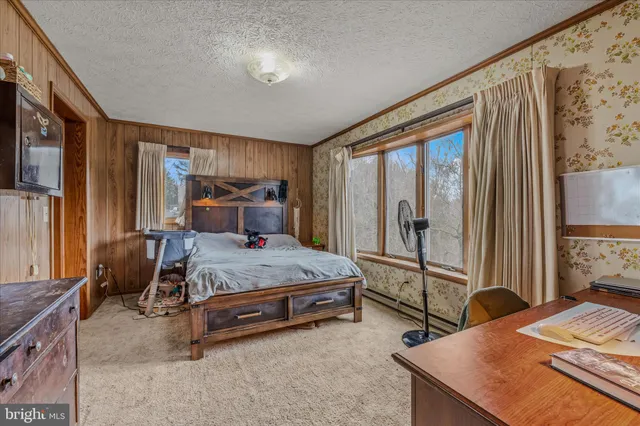 a bedroom with a bed and large windows