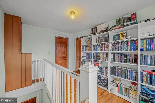 a view of an empty room with wooden floor fireplace and a window