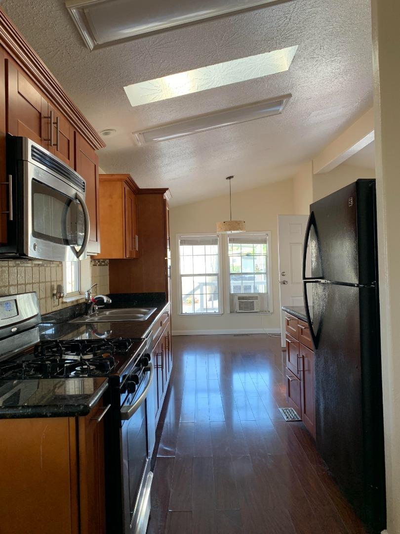 1201 Sycamore Terrace, Unit 87 Sunnyvale, CA 94086 - Photo 14 of 26 a kitchen with granite countertop a stove and a wooden floor
