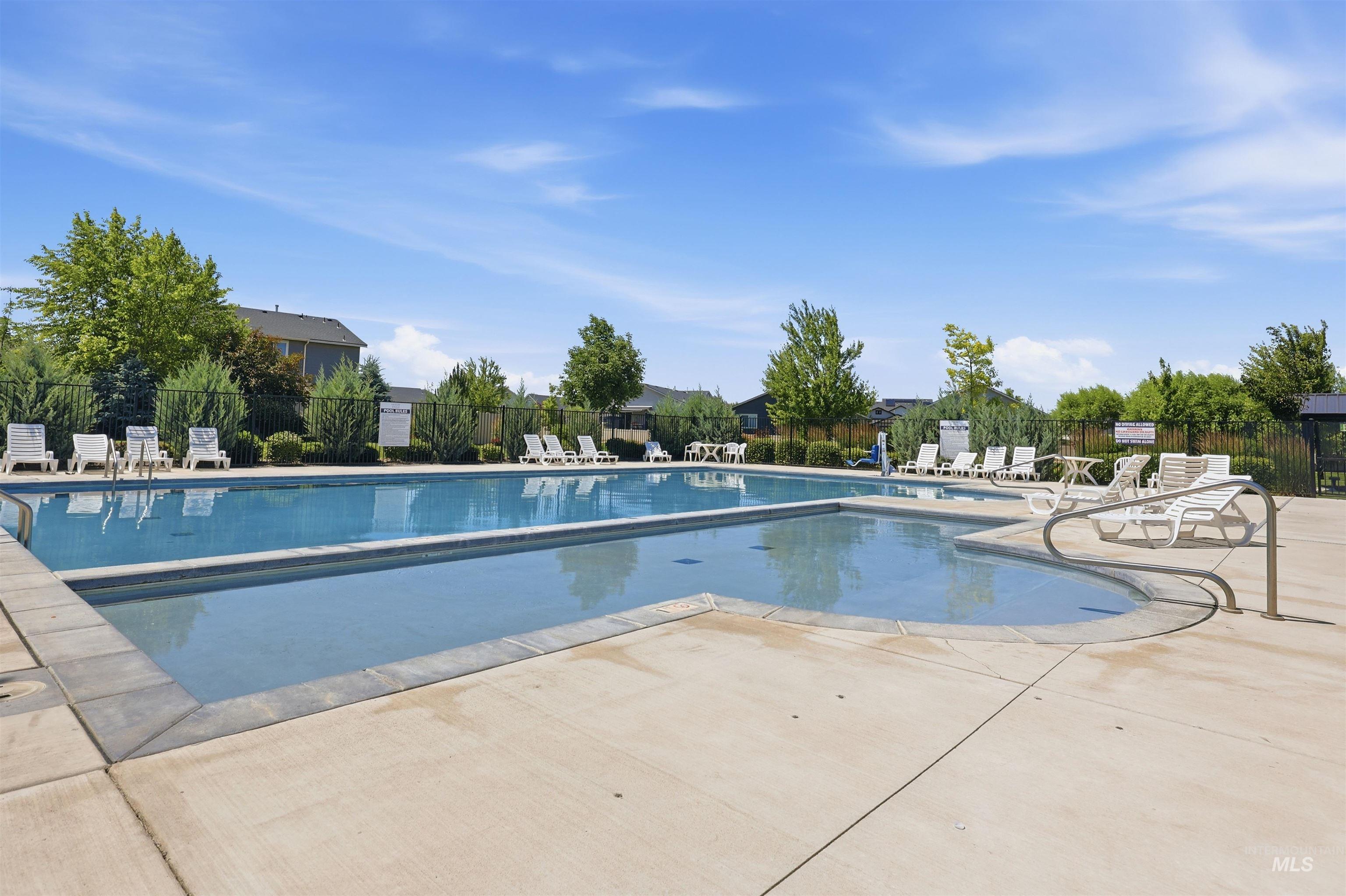 3811 West Maypearl Street Meridian, ID 83642 - Photo 39 of 39 Outdoor swimming pool with integrated shallow area, surrounded by a concrete deck and a black metal fence