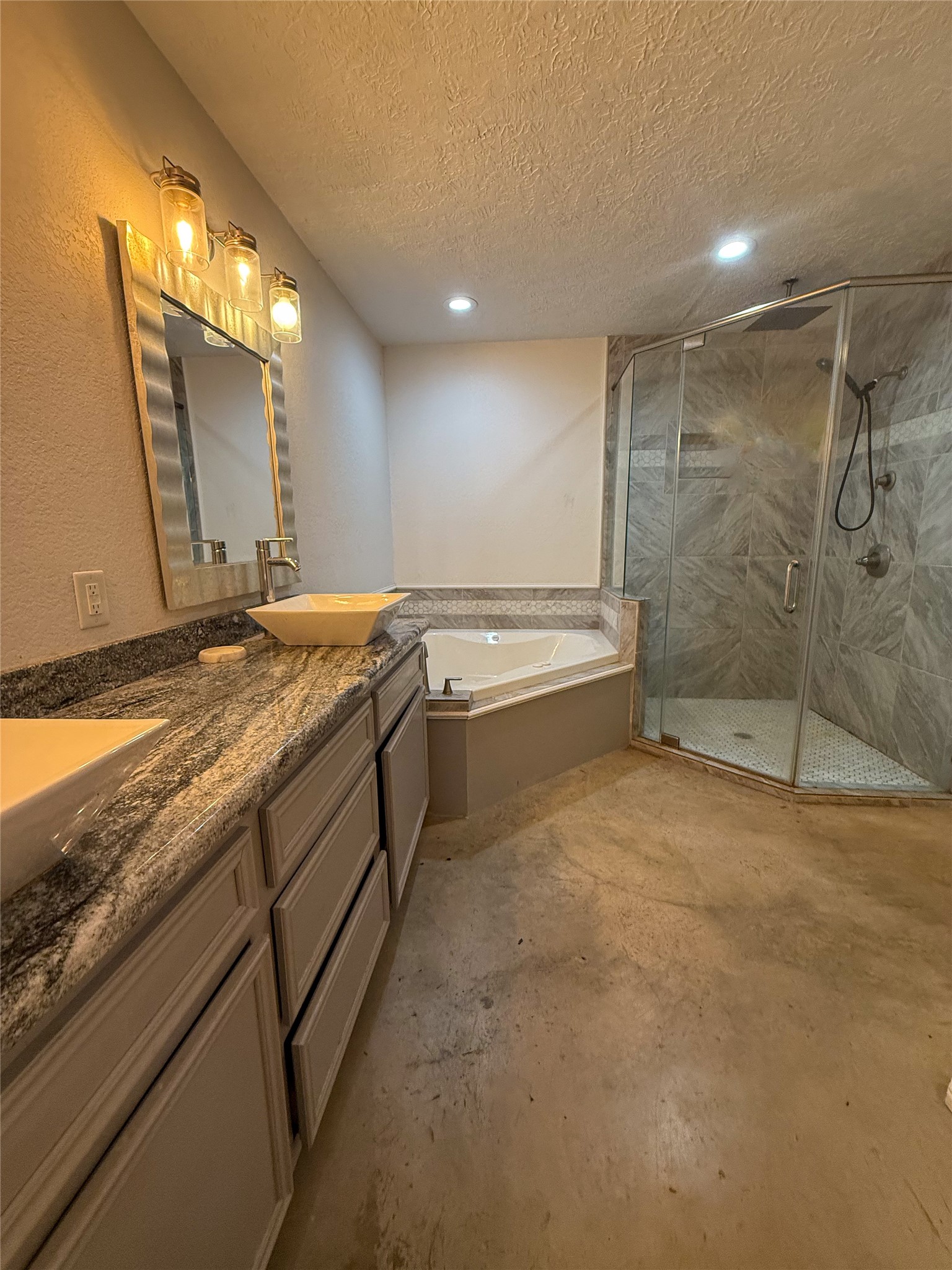 107 County Road 409 Sweeny, TX 77480 - Photo 11 of 20 This modern bathroom features dual sinks with granite countertops, a large corner bathtub, and a sleek glass-enclosed shower. Recessed lighting and stylish fixtures enhance the elegant look.