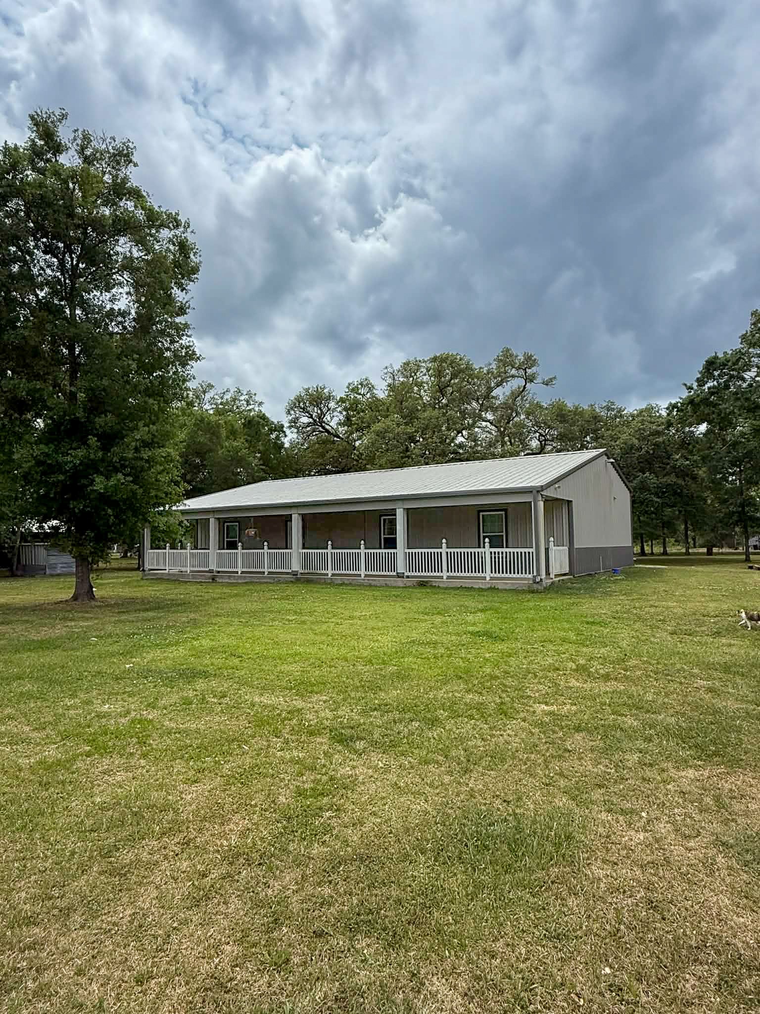 107 County Road 409 Sweeny, TX 77480 - Photo 2 of 20 Charming single-story home with a spacious front porch and a large, grassy yard. Surrounded by mature trees, it offers a serene and private setting. Perfect for those seeking a peaceful retreat.