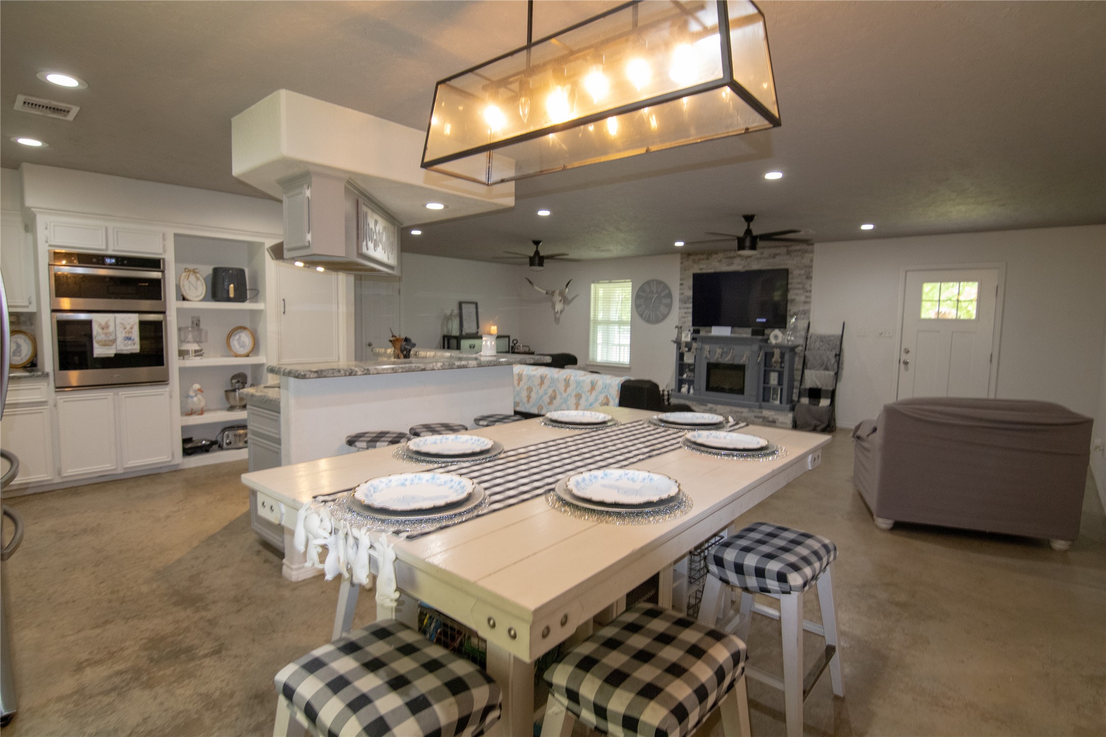 107 County Road 409 Sweeny, TX 77480 - Photo 8 of 20 This open-concept living space features a modern kitchen with built-in appliances, a large dining area, and a cozy living area. The room is bright and inviting, with stylish lighting and neutral tones.