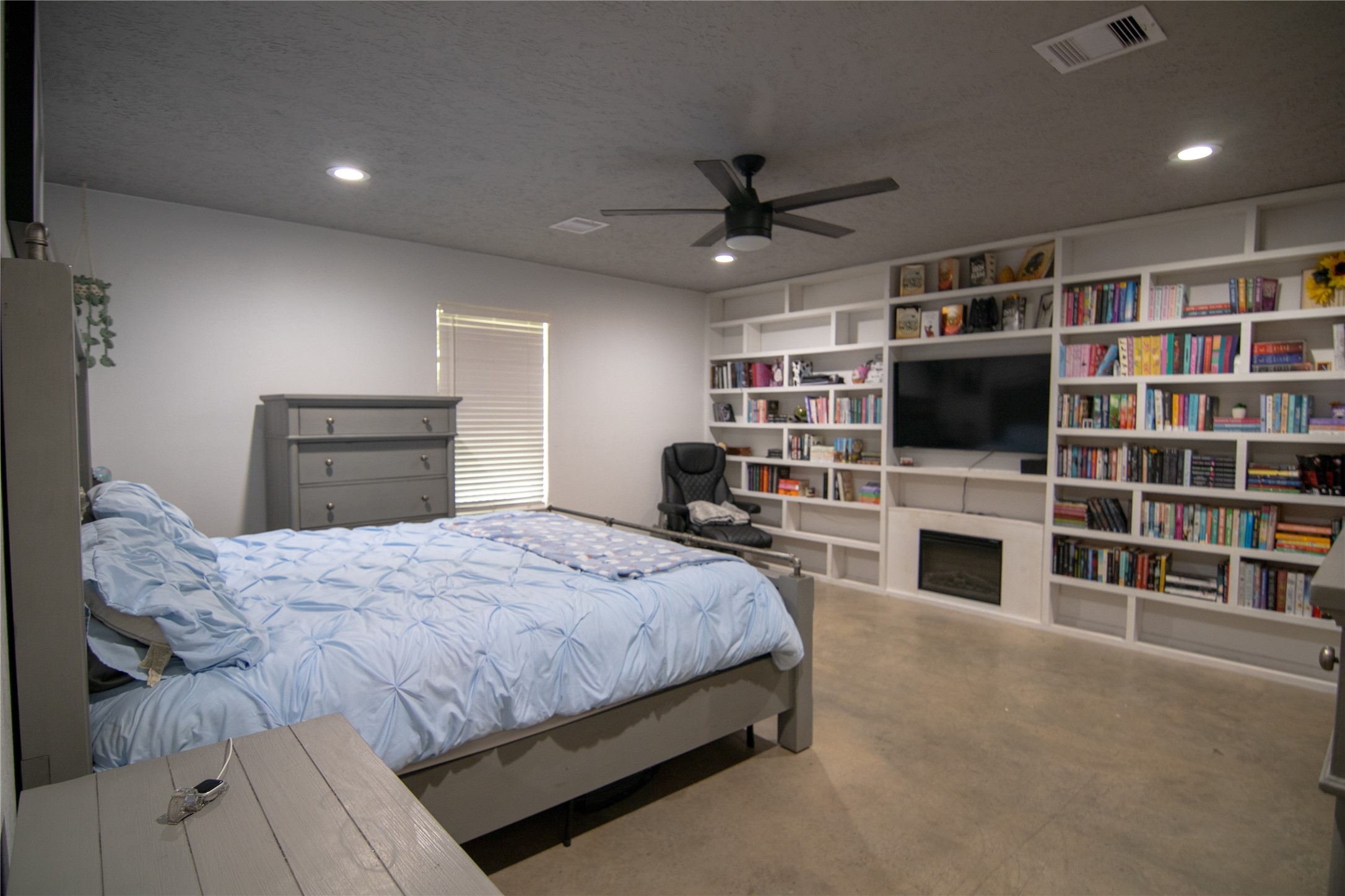 107 County Road 409 Sweeny, TX 77480 - Photo 9 of 20 This spacious bedroom features a modern design with built-in bookshelves. This cozy room features ample natural light, and sleek flooring, offering comfort and practicality.