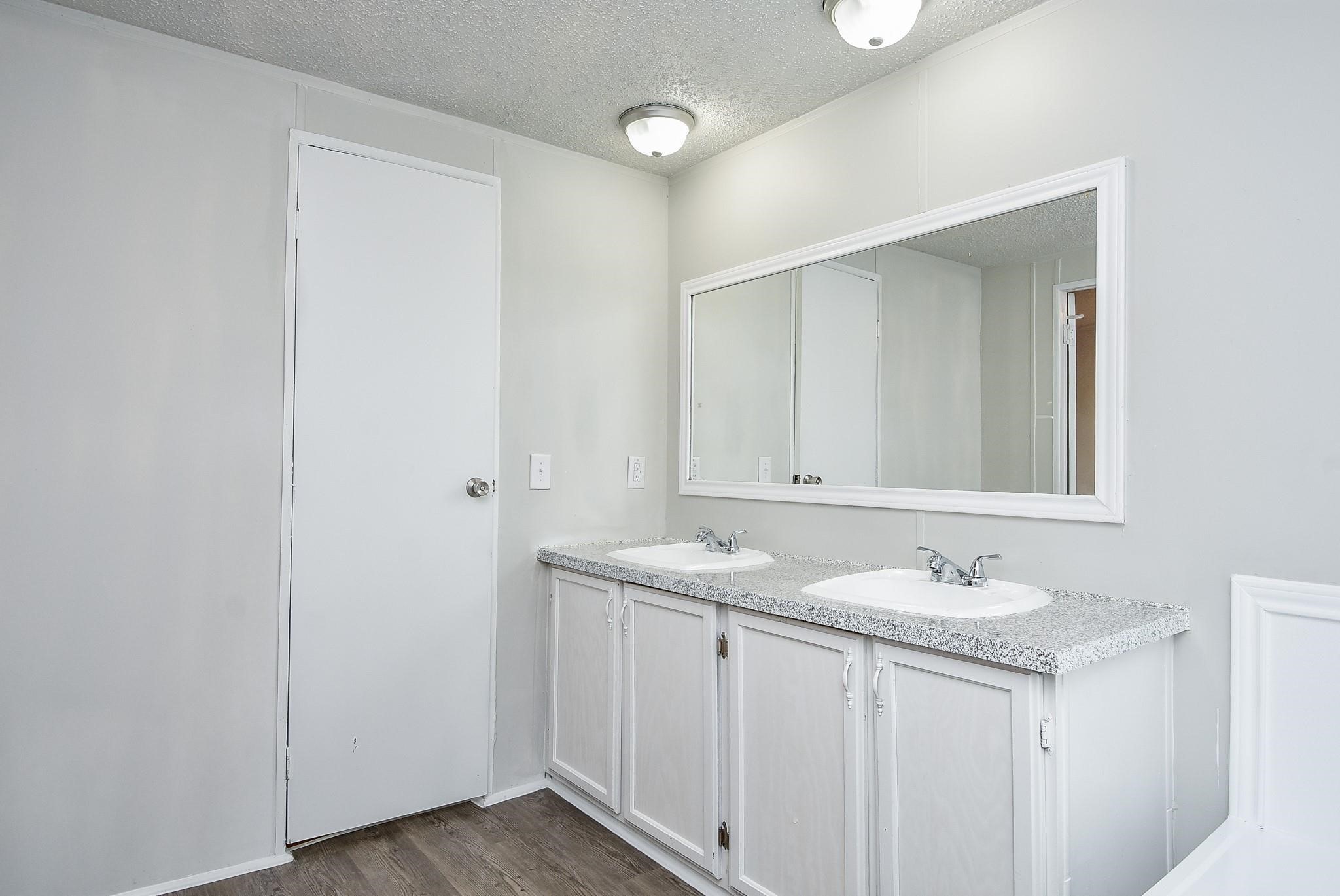 12842 Roy Harris Loop Conroe, TX 77306 - Photo 30 of 36 a bathroom with a granite countertop sink and a mirror