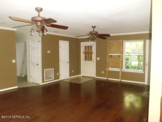 1800 Bennett Road St. Augustine, FL 32092 - Photo 4 of 24 a view of a livingroom with wooden floor and a ceiling fan