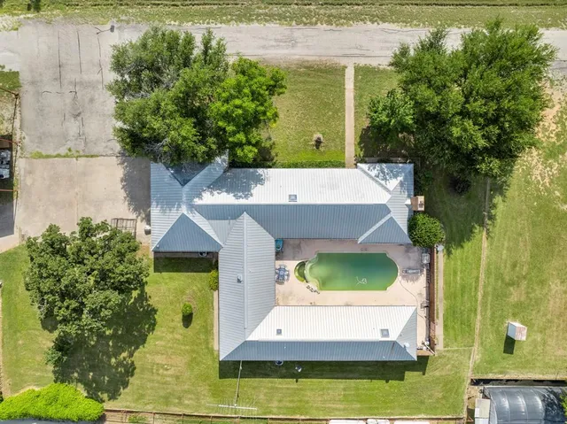 an aerial view of a house with a yard swimming pool and outdoor seating