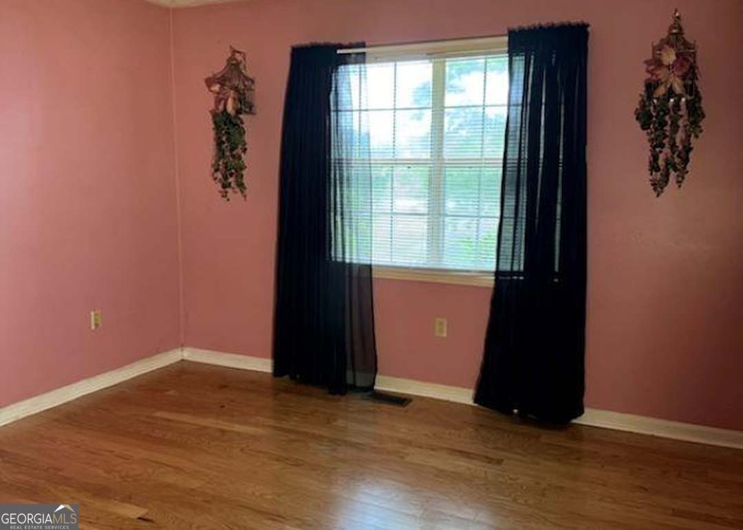 2304 Cummings Road Fort Valley, GA 31030 - Photo 7 of 20 an empty room with wooden floor and windows