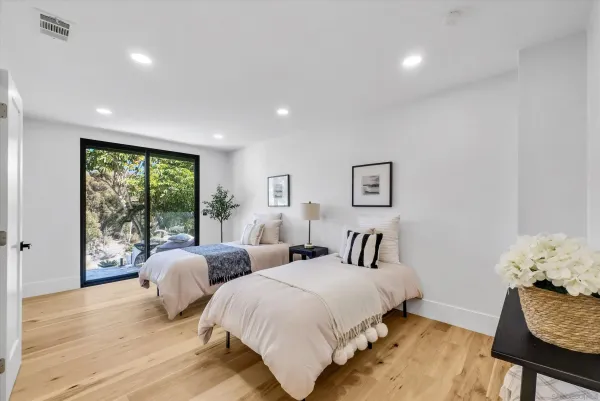 a spacious bedroom with two beds and a large window