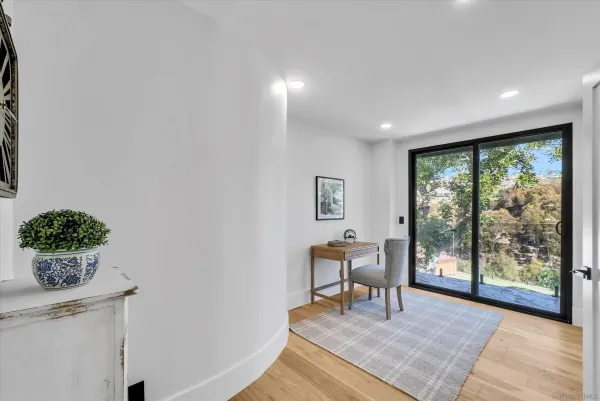 a view of a livingroom with wooden floor and a potted plant