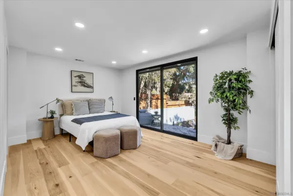 a spacious bedroom with a large bed and a potted plant