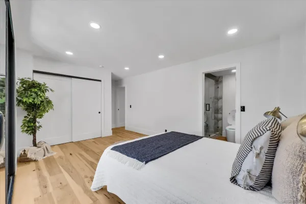 a bedroom with a bed and a potted plant