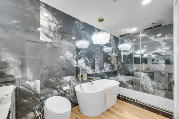 a bathroom with a bathtub shower sink mirror and toilet
