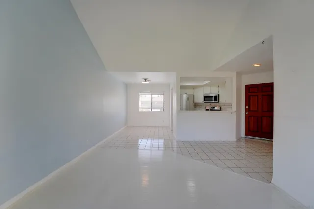 a view of entryway with wooden floor and a kitchen