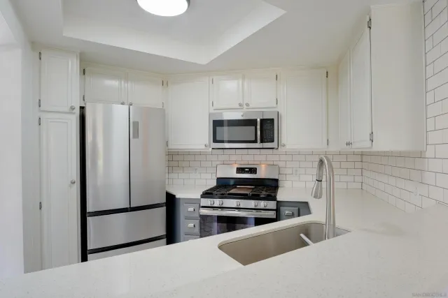 a kitchen with stainless steel appliances a refrigerator stove microwave and sink