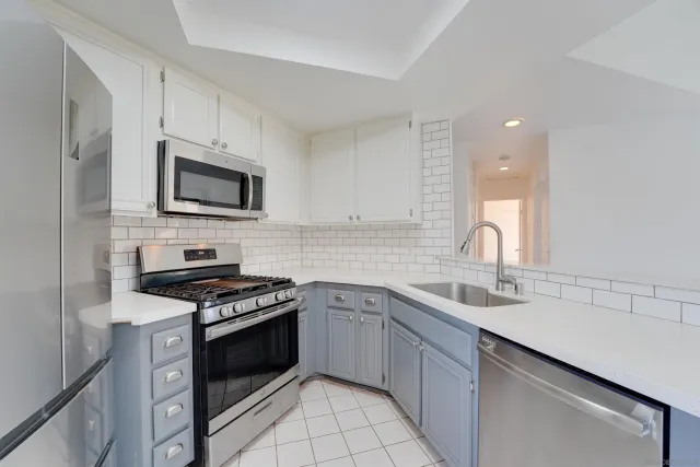 a kitchen with cabinets stainless steel appliances a sink and a counter top space