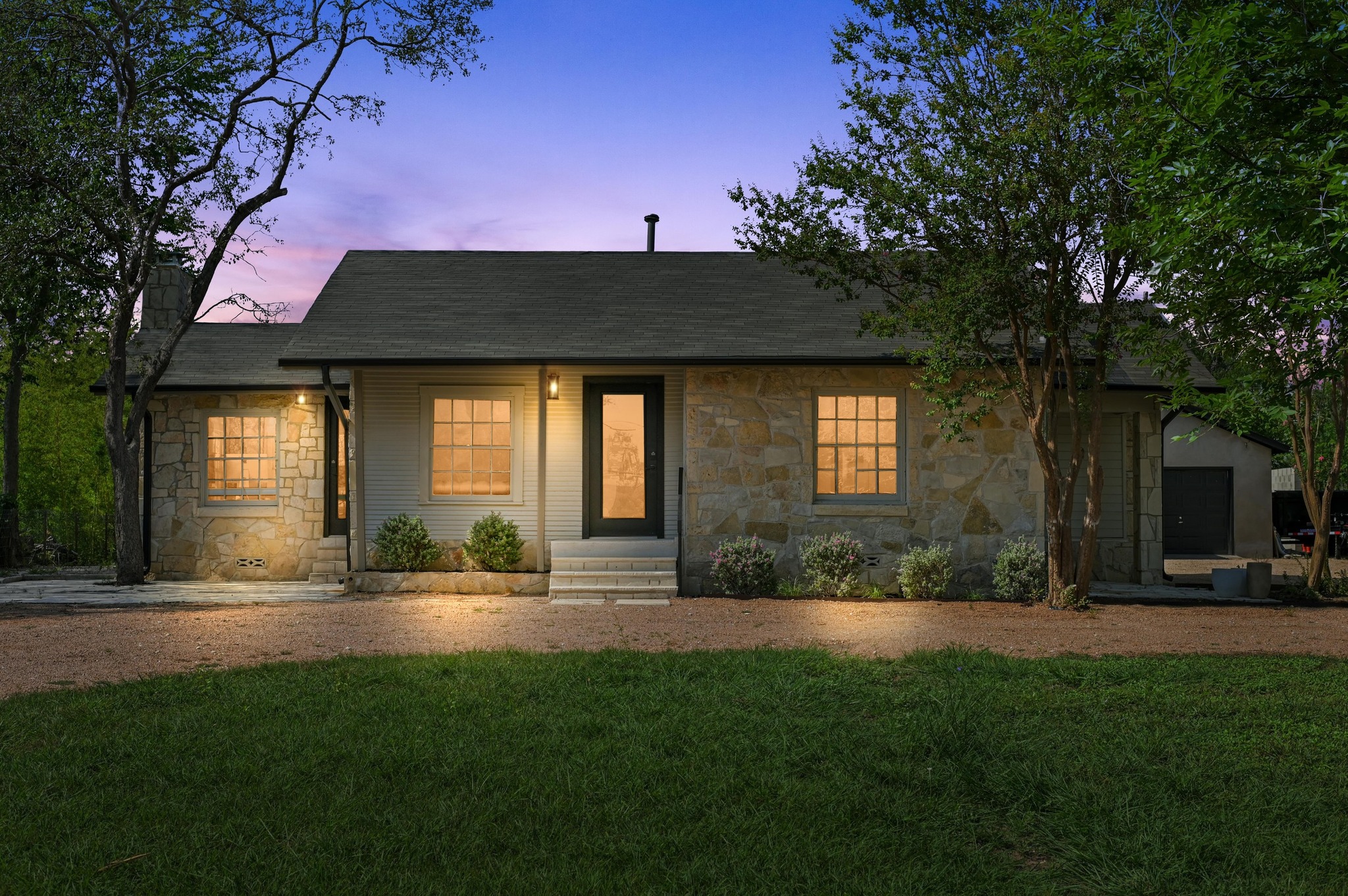 Ranch-style house with stone siding, a front yard, roof with shingles, and a chimney