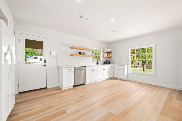 a view of a kitchen with wooden floor and electronic appliances