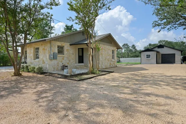 a view of a house with backyard and a tree
