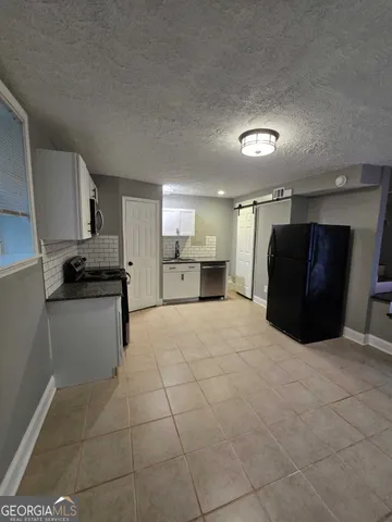 a kitchen with a refrigerator and a stove top oven