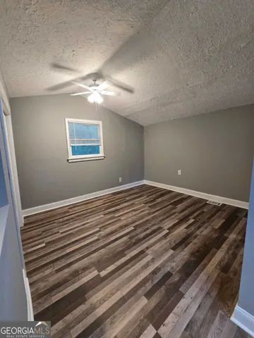 a view of a room with wooden floor and fan