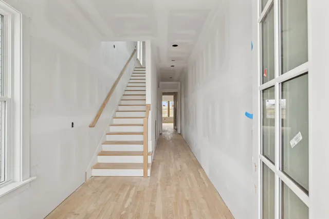 a view of a hallway with wooden floor and entryway