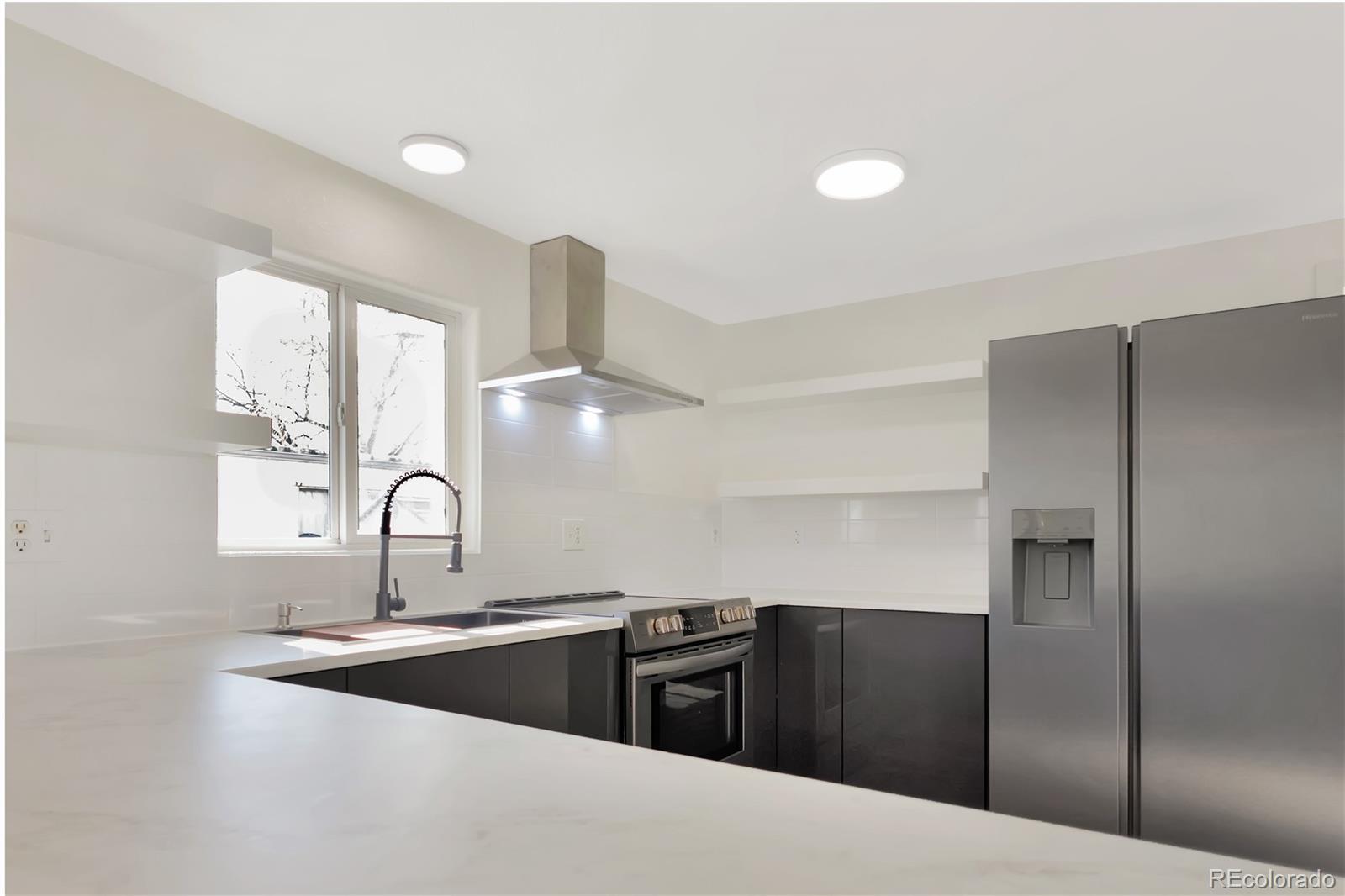8533 Cook Court Denver, CO 80229 - Photo 3 of 15 a kitchen with stainless steel appliances granite countertop a refrigerator and sink