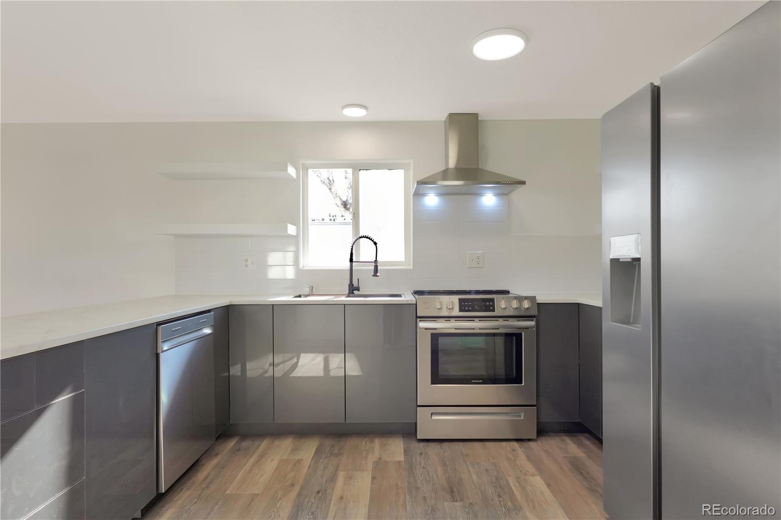 8533 Cook Court Denver, CO 80229 - Photo 4 of 15 a kitchen with stainless steel appliances a stove and a refrigerator