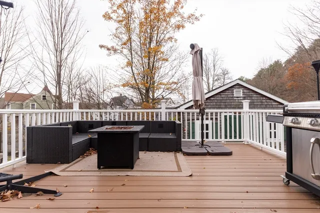 a view of a deck with wooden floor and fence with a bench
