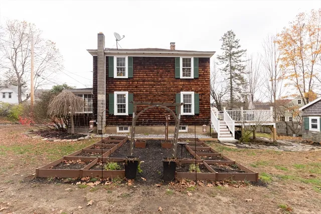 a view of a house with a yard and large tree