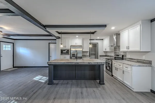 a kitchen with cabinets wooden floor and stainless steel appliances