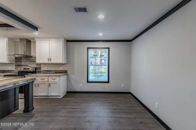 a view of a kitchen with a sink dishwasher and wooden floor