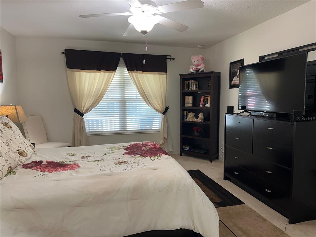 Undisclosed Address Tavares, FL 32778 - Photo 11 of 29 a bedroom with a bed and a flat screen tv