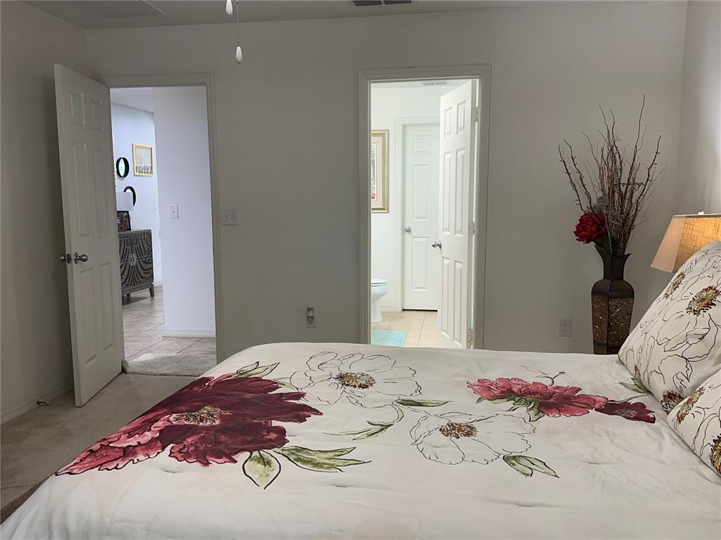 Undisclosed Address Tavares, FL 32778 - Photo 12 of 29 a bedroom with a bed and a mirror