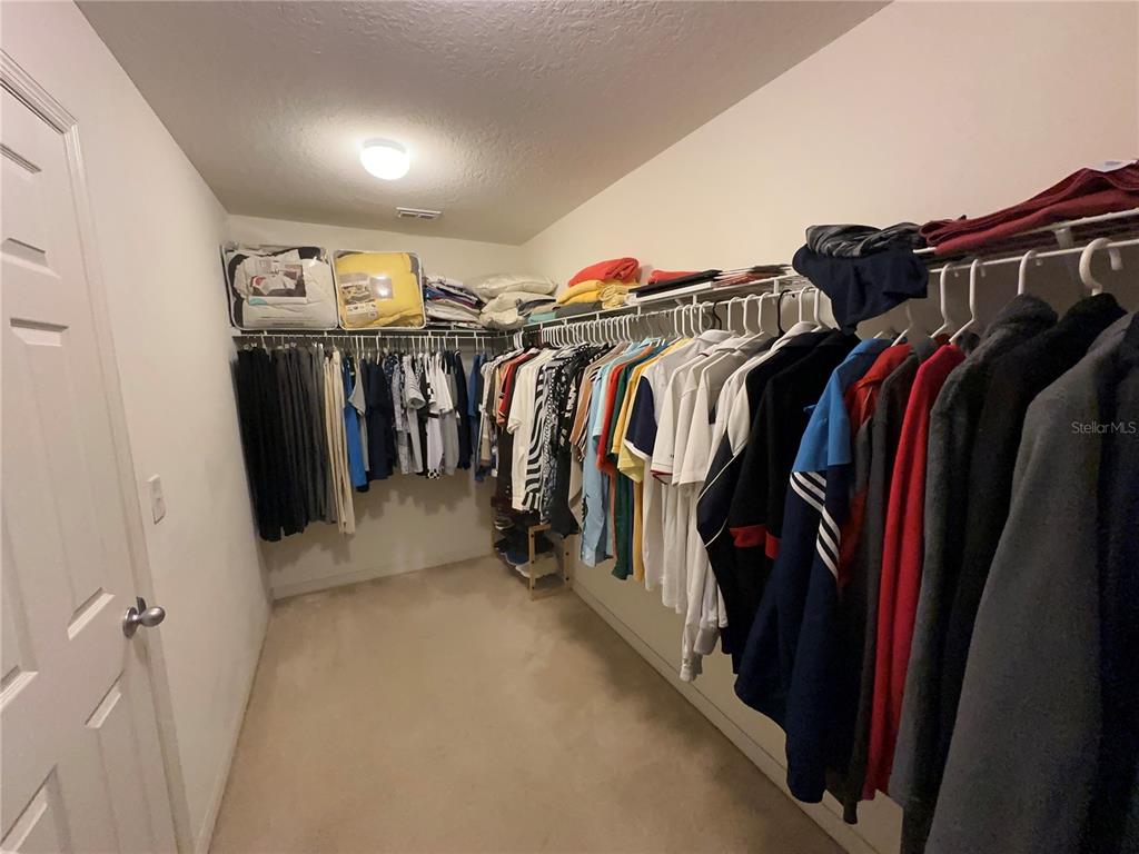 Undisclosed Address Tavares, FL 32778 - Photo 16 of 29 a view of walk in closet with clothes and shoes