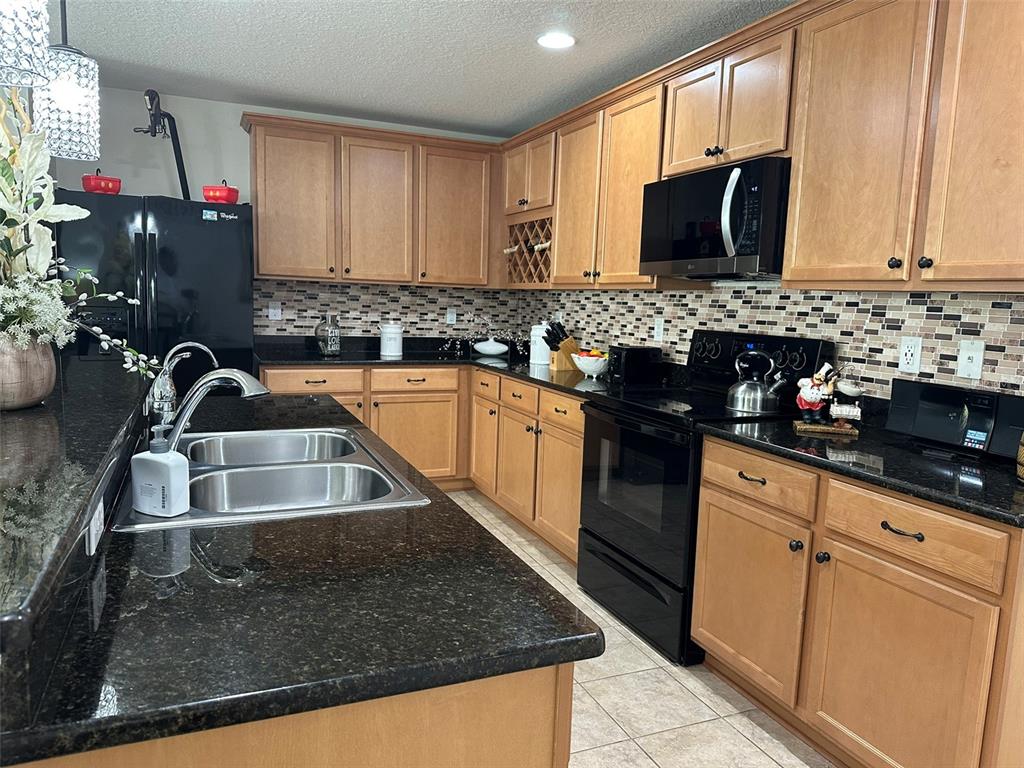 Undisclosed Address Tavares, FL 32778 - Photo 7 of 29 a kitchen with granite countertop a sink stainless steel appliances and cabinets