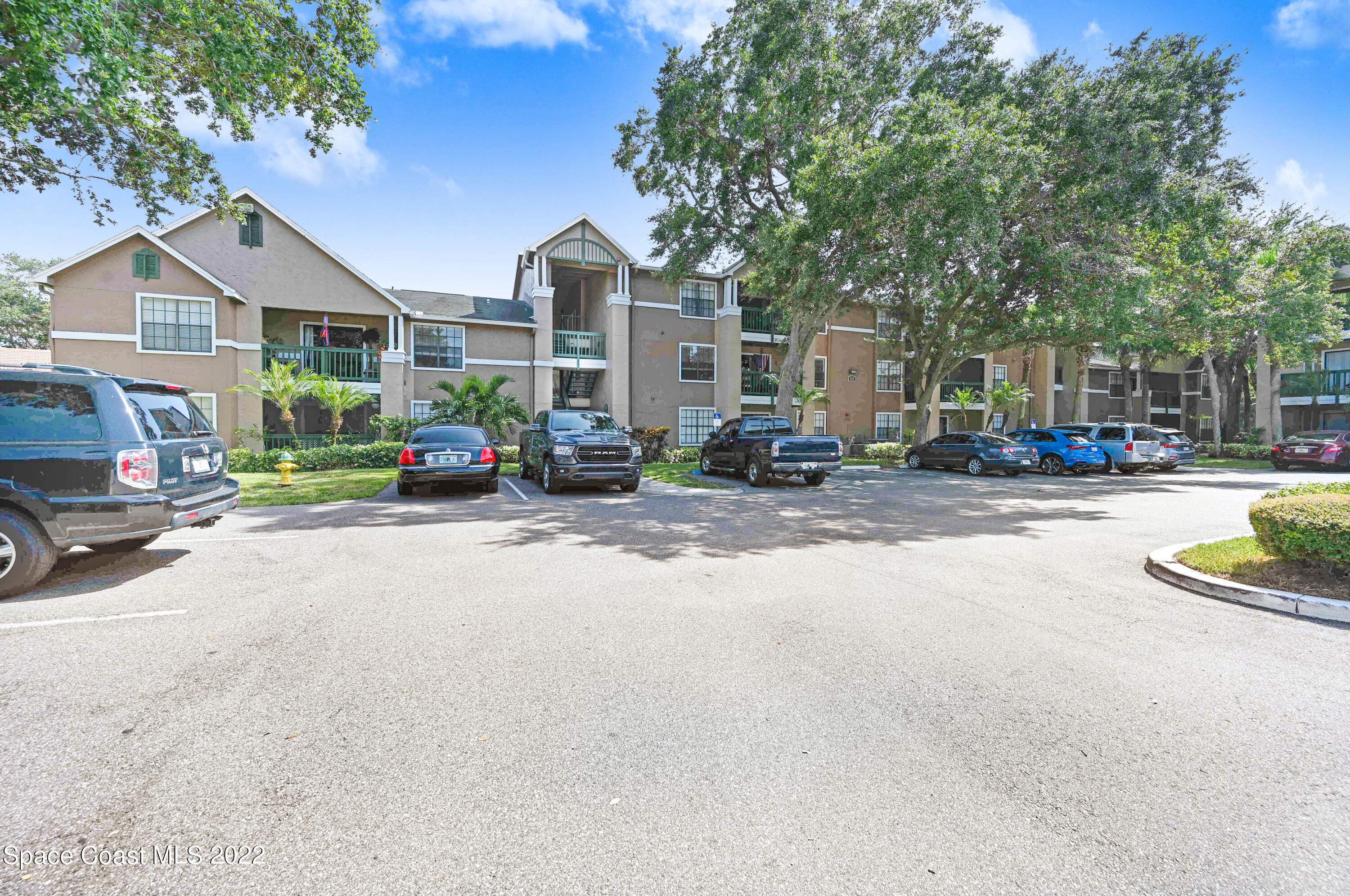 a view of a house with a cars park side of a road