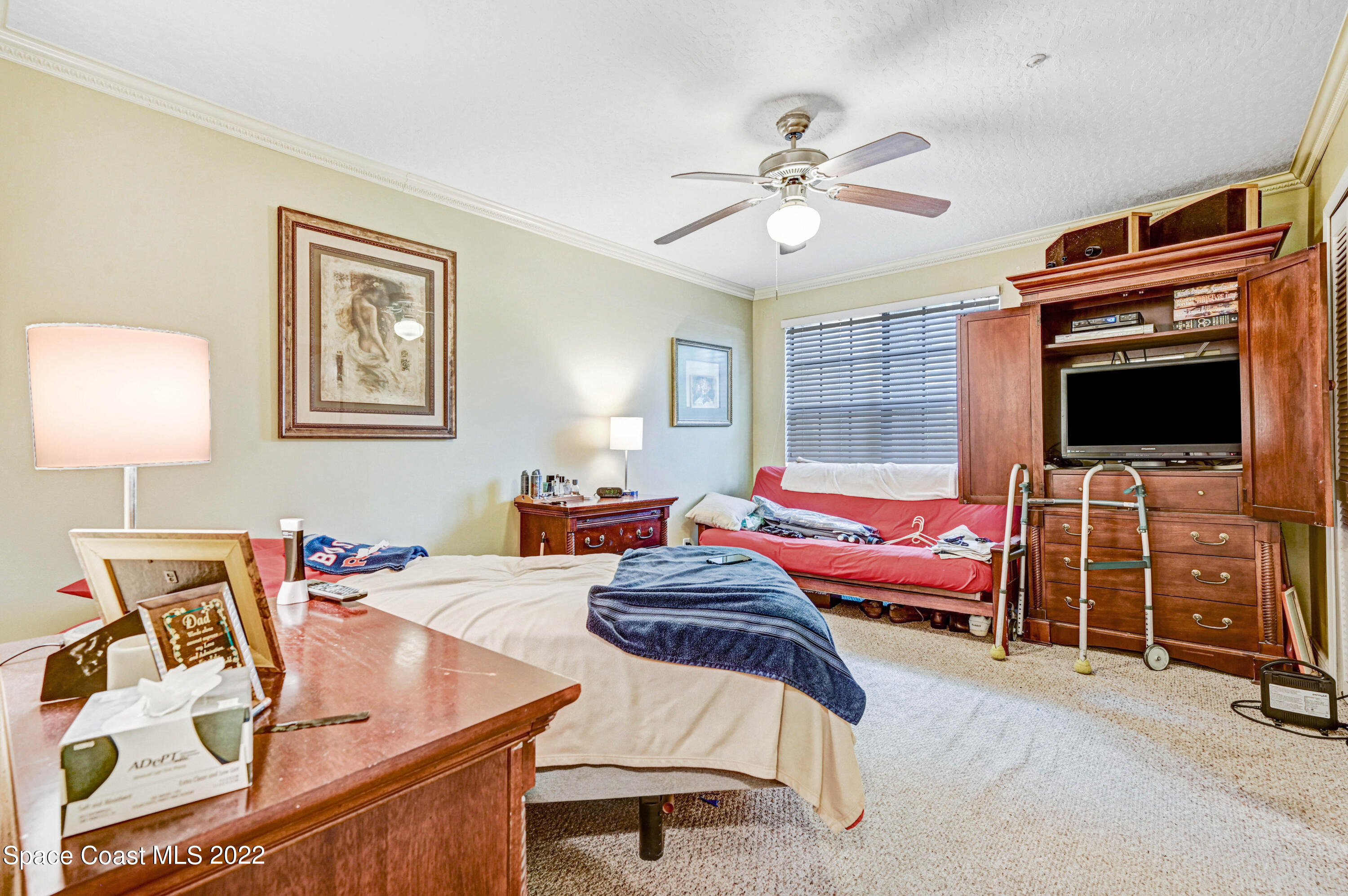 7667 North Wickham Road, Unit 107 Melbourne, FL 32940 - Photo 15 of 26 a bedroom with furniture and a flat screen tv