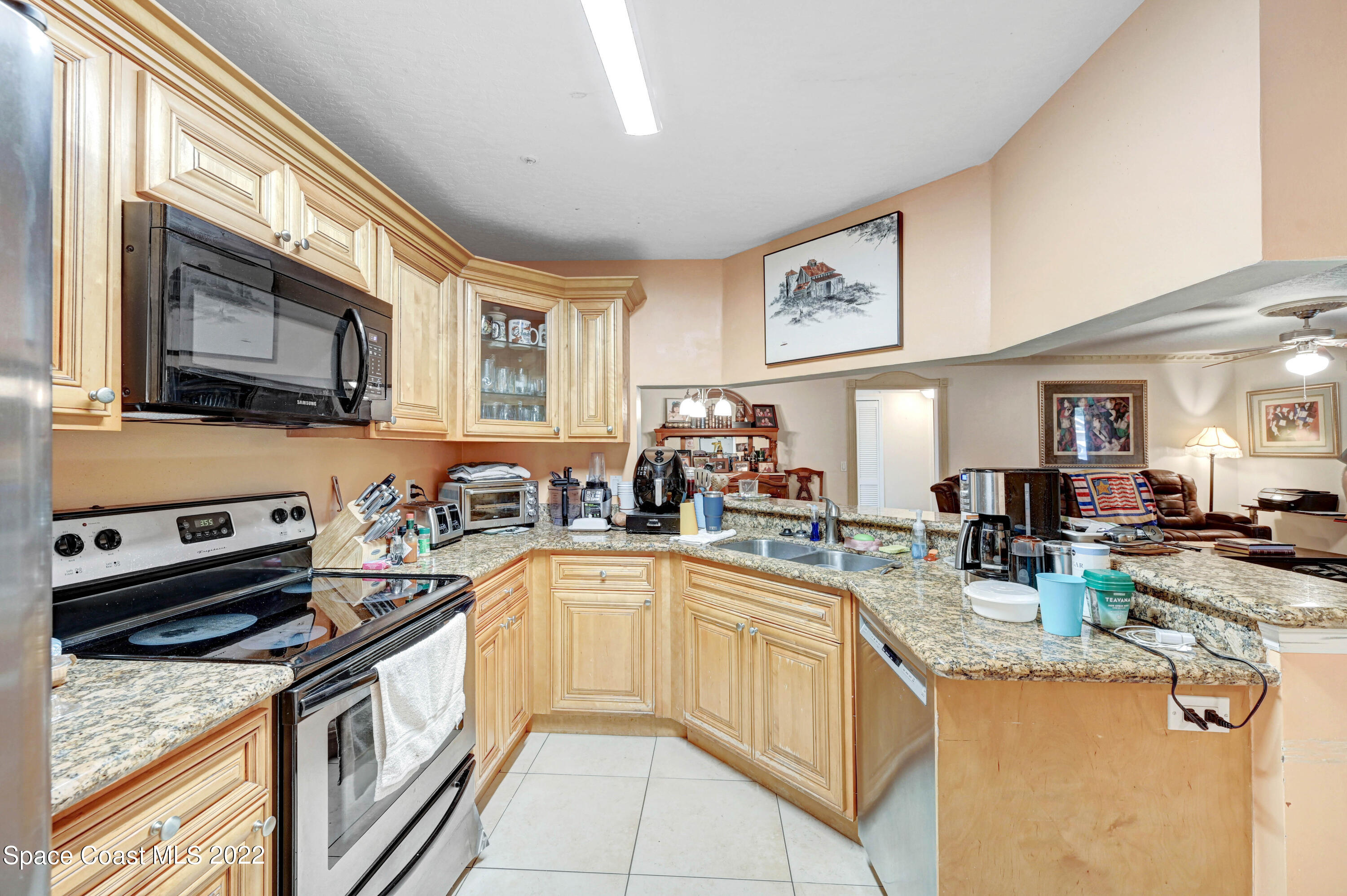 7667 North Wickham Road, Unit 107 Melbourne, FL 32940 - Photo 7 of 26 a kitchen with stainless steel appliances granite countertop a stove sink and cabinets