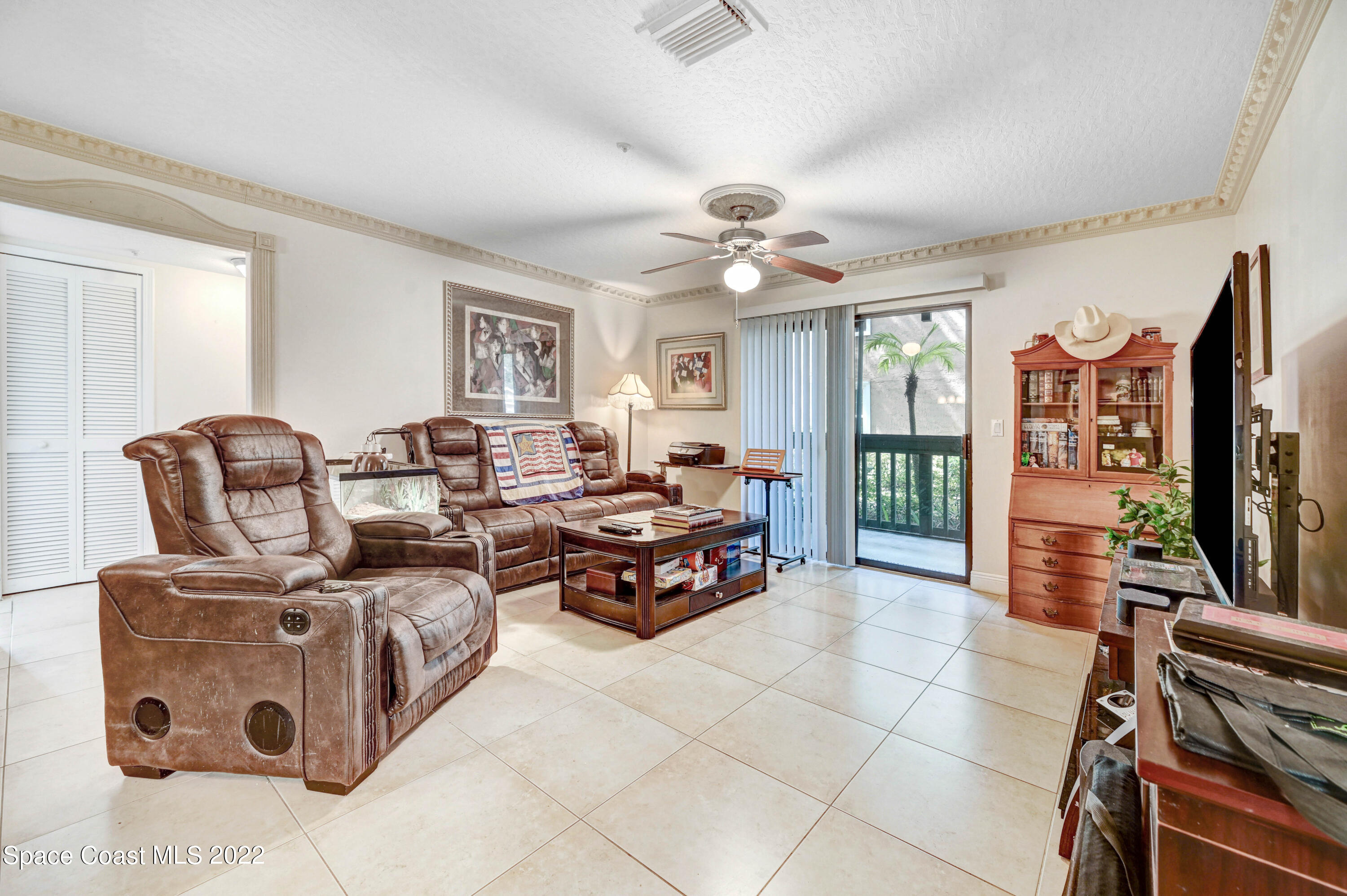 7667 North Wickham Road, Unit 107 Melbourne, FL 32940 - Photo 8 of 26 a living room with furniture and a flat screen tv