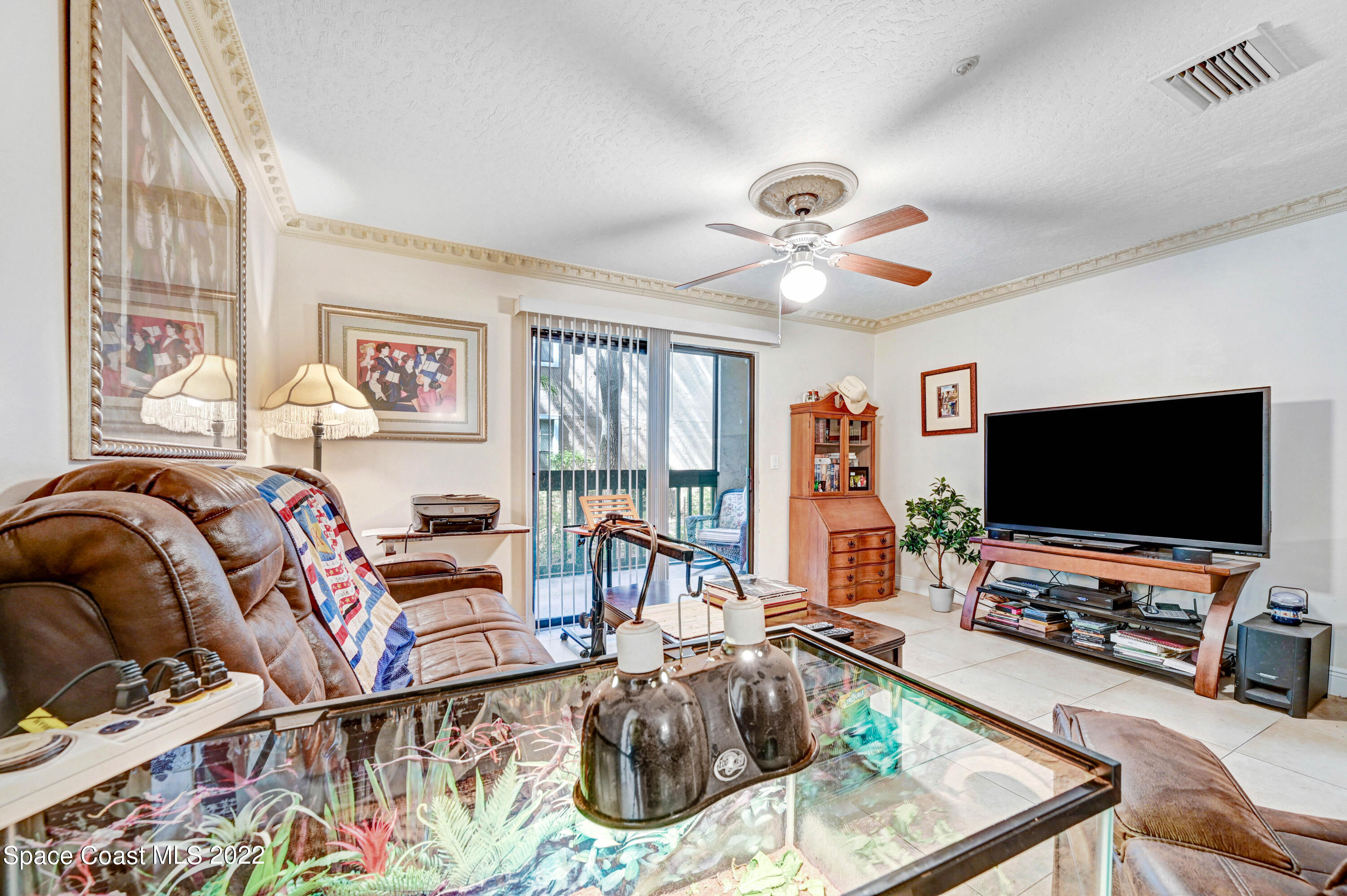 7667 North Wickham Road, Unit 107 Melbourne, FL 32940 - Photo 10 of 26 a living room with furniture and a flat screen tv