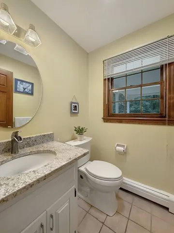 a bathroom with a granite countertop toilet sink and mirror