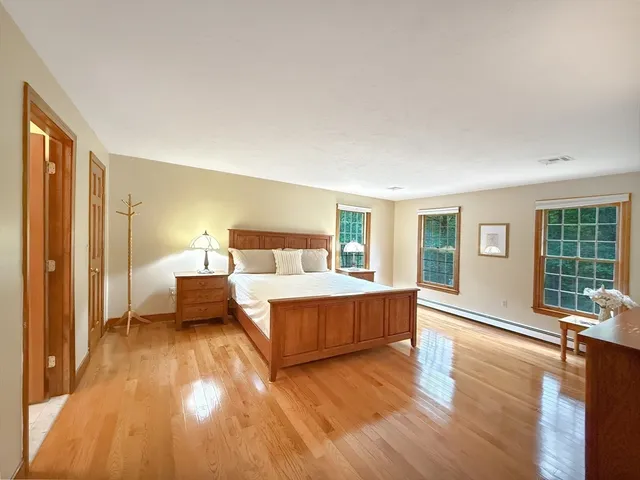 a bedroom with a large bed and a wooden floor