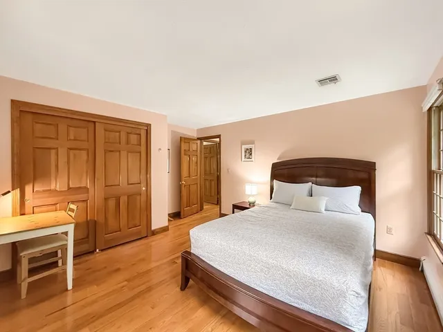 a bedroom with a bed and wooden floor