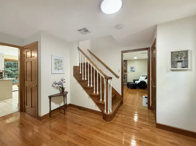 a view of a hallway with wooden floor and stairs